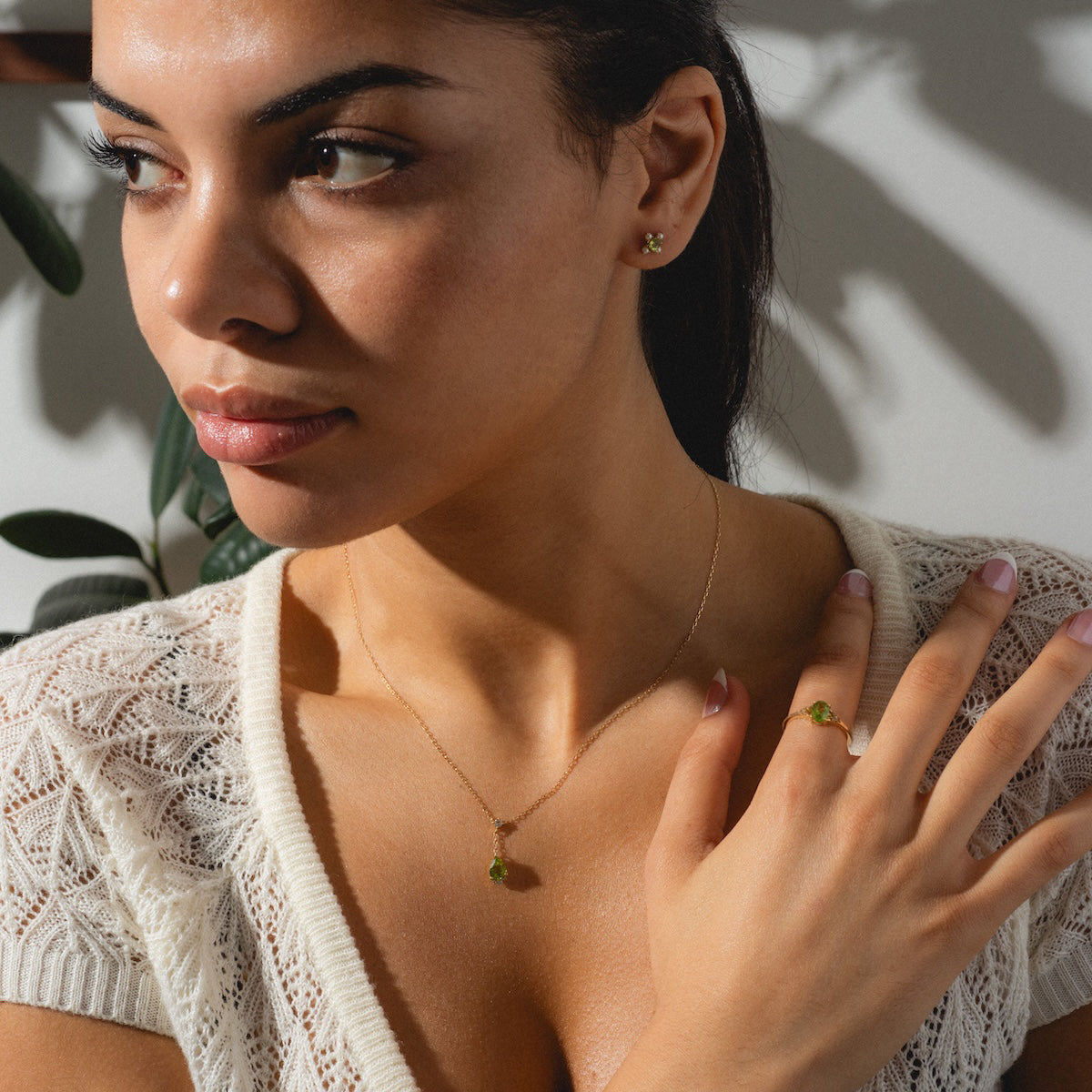Peridot statement ring, necklace, and earrings worn by woman