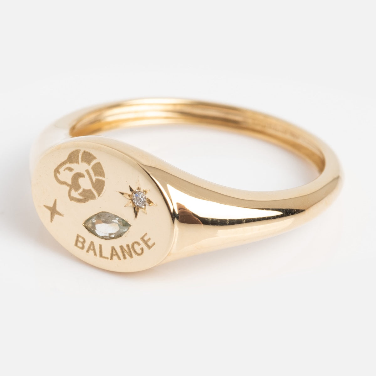 Gold ring with zodiac symbol and 'Balance' engraving on a white background