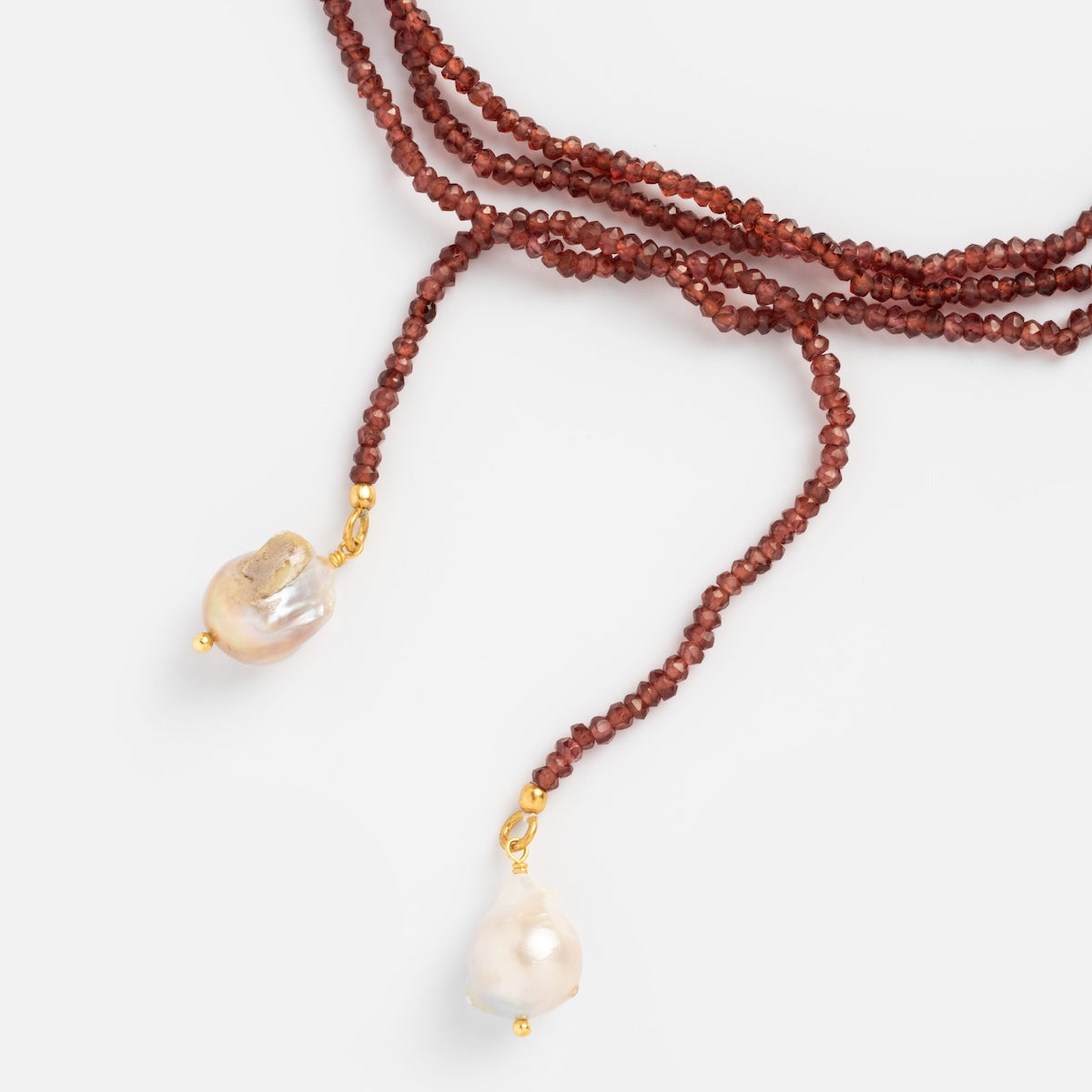 Close up of beaded garnet tie necklace with pearls