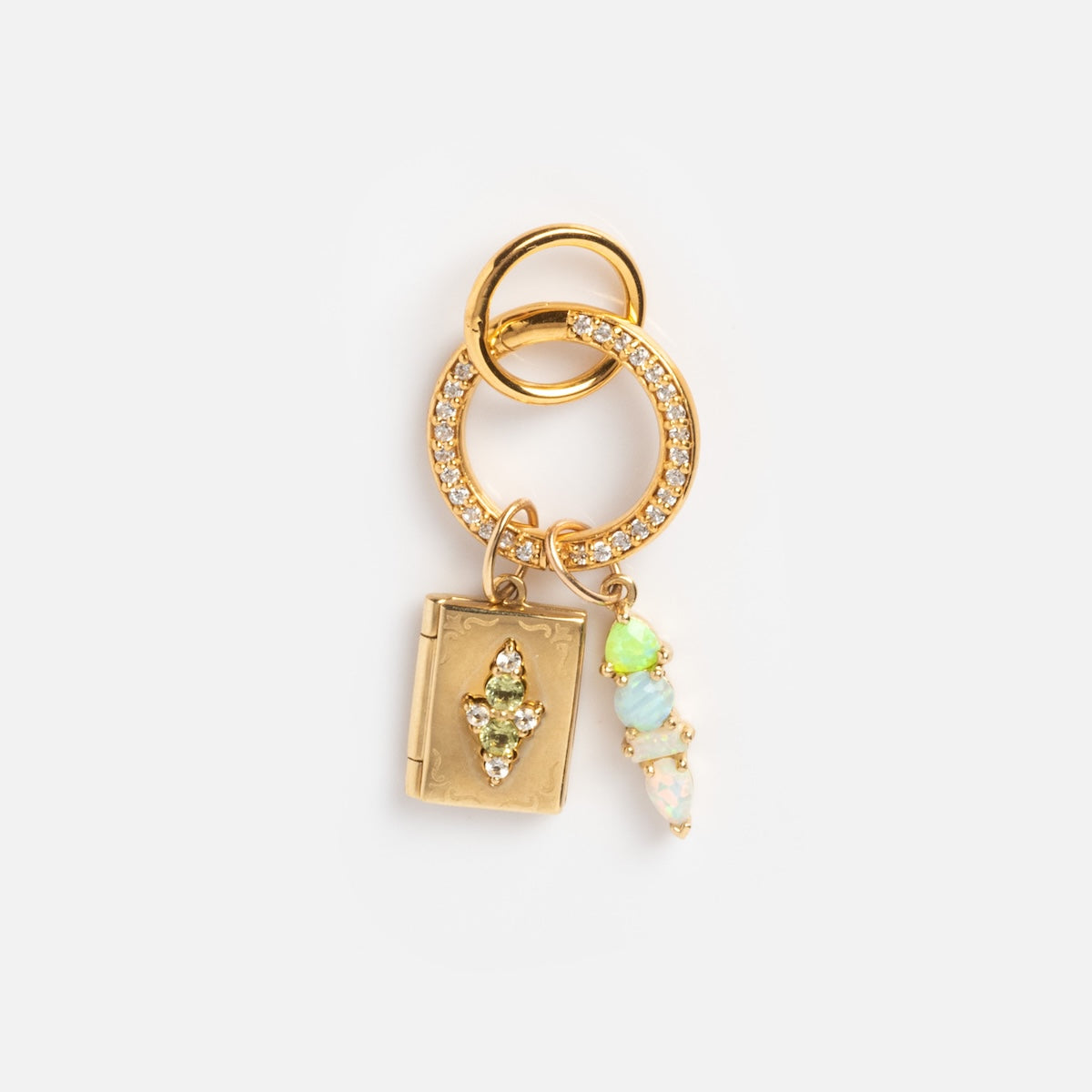 The Charm Clip is a gold keychain with two interlocking rings, one adorned with crystals. It includes a gold vermeil book charm with a green gem and pastel opalescent beads—ideal for pairing with bracelet charms.
