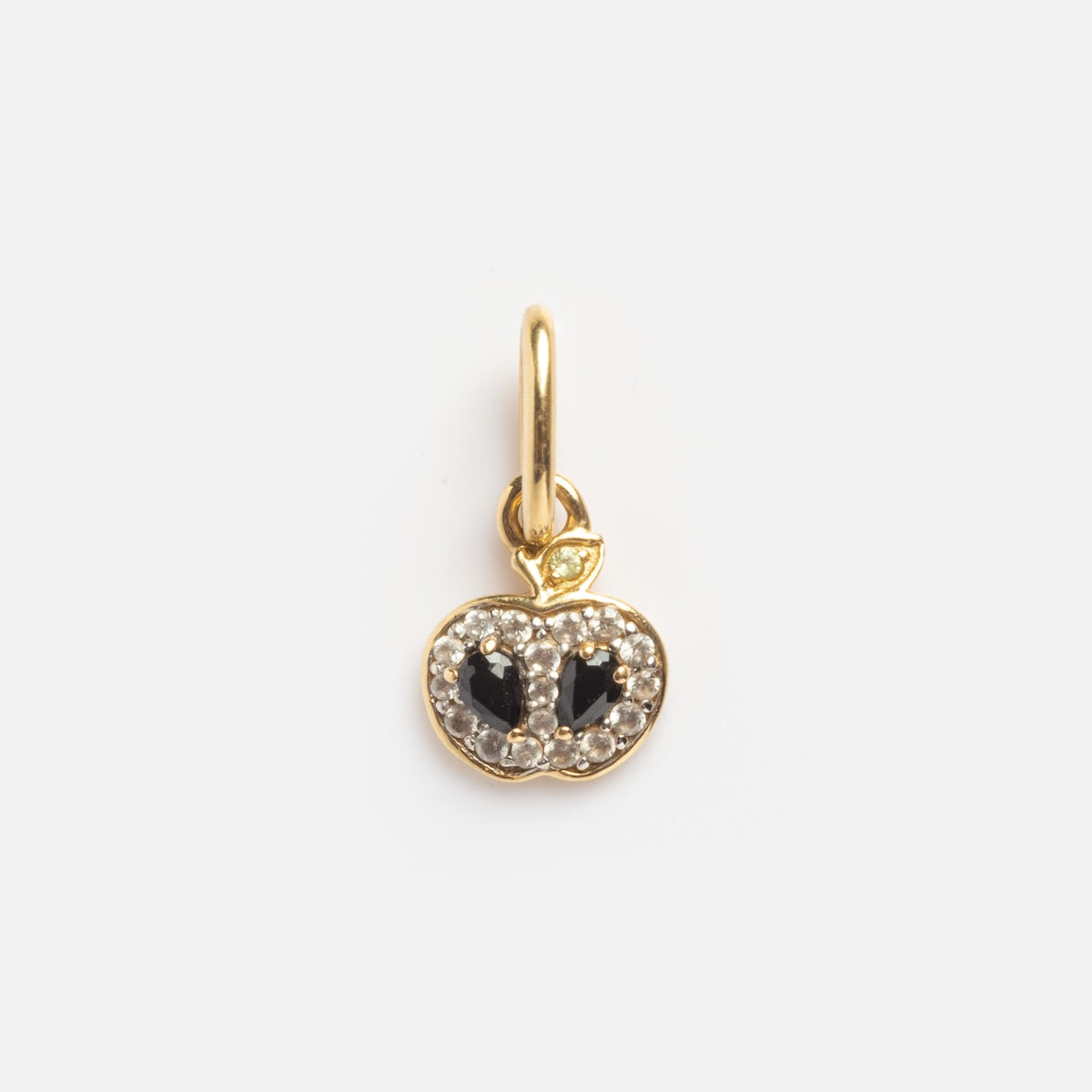 The Solid Gold Half Apple Charm Sample features a gold apple shape with two black center stones, small clear outlining stones, and is attached to a gold loop.