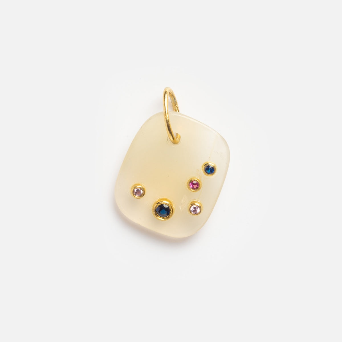 The White Chalcedony Aries Constellation Charm Sample is a square, translucent cream-colored pendant with a gold loop, featuring small pink, blue, and clear gemstones set into the surface.