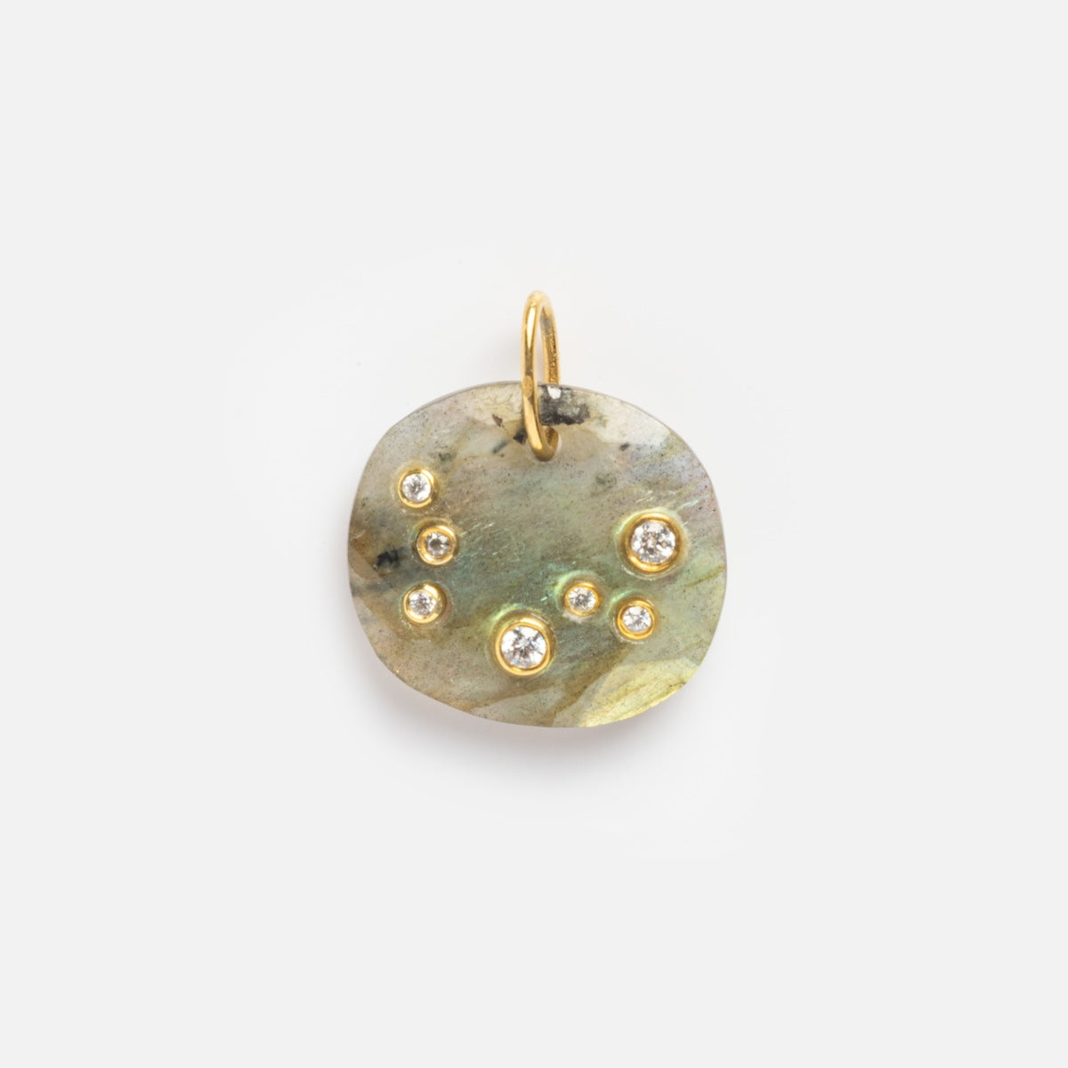 The Labradorite Pisces Constellation Charm Sample is a small, irregular charm with a marbled labradorite look, seven round gemstones of different sizes, and a gold loop for attaching to a chain.