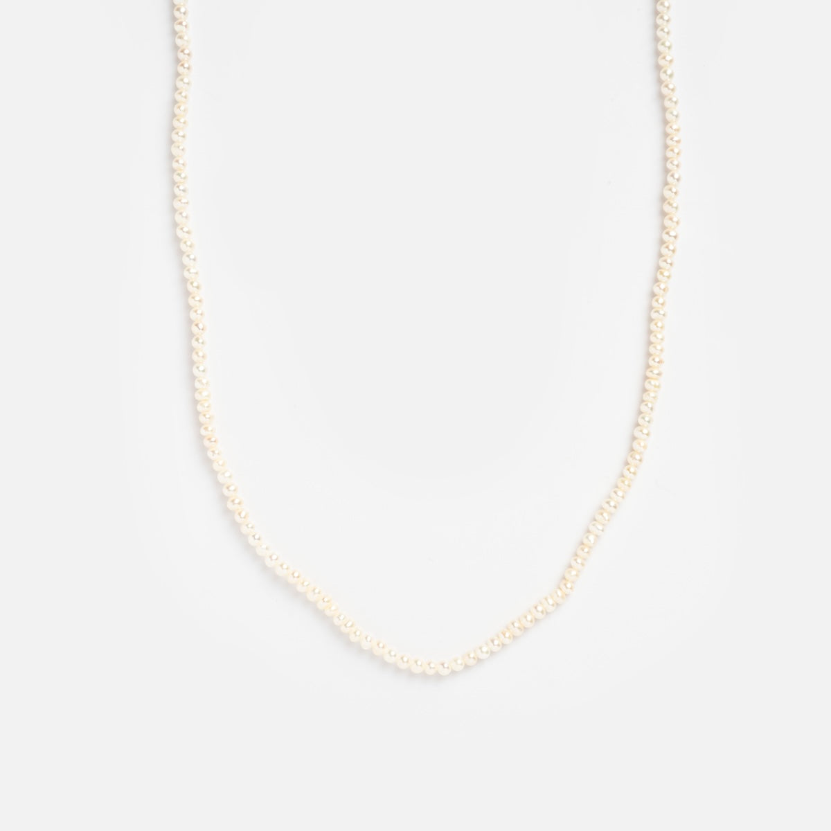 The Delicate Pearl Necklace Sample features a single strand of small white pearls, showcased against a plain white background.