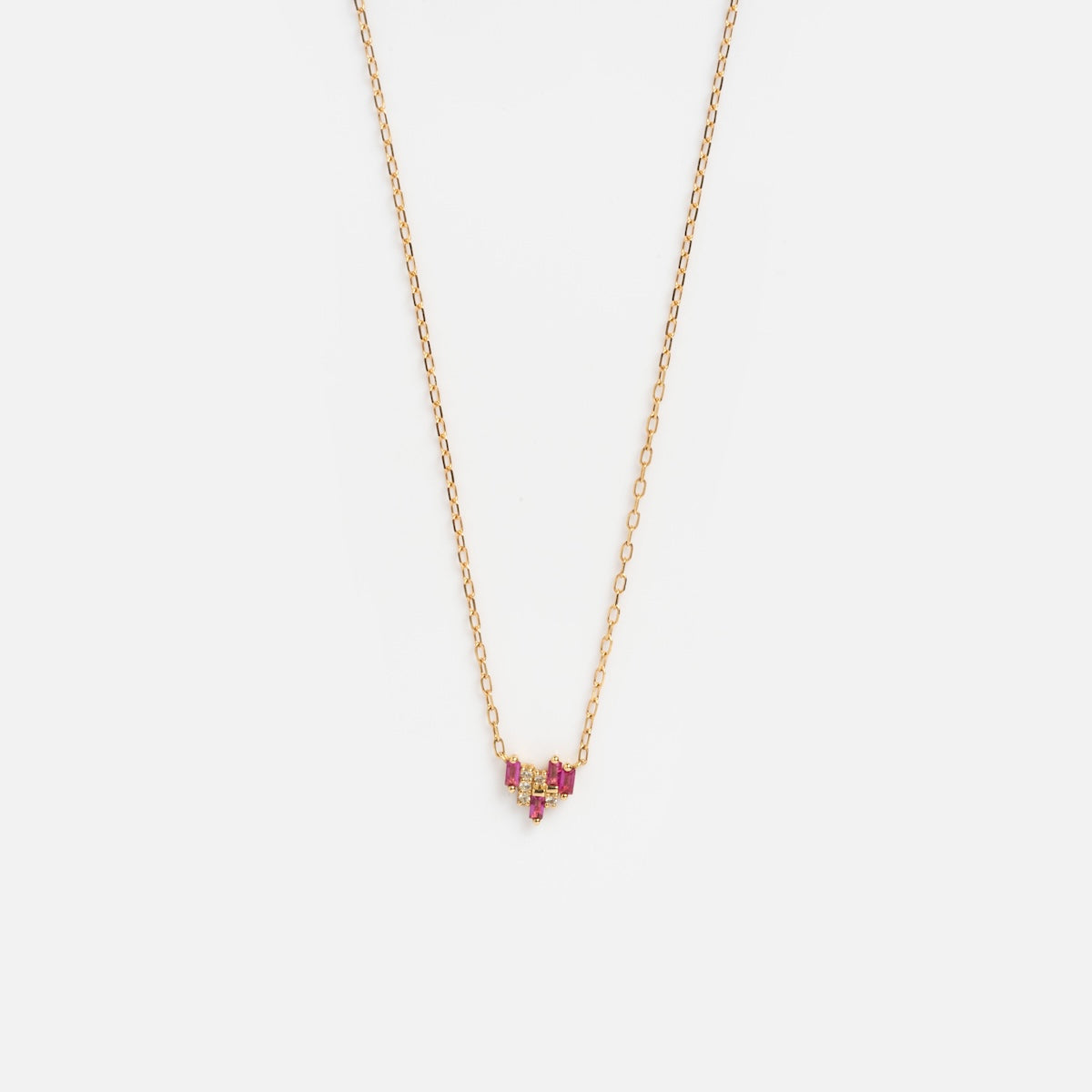 The Solid Gold Geometric Ruby and Sapphire Necklace Sample features a delicate yellow gold chain with a small geometric pendant accented by lab-created rubies in a subtle V shape, shown on a plain white background.