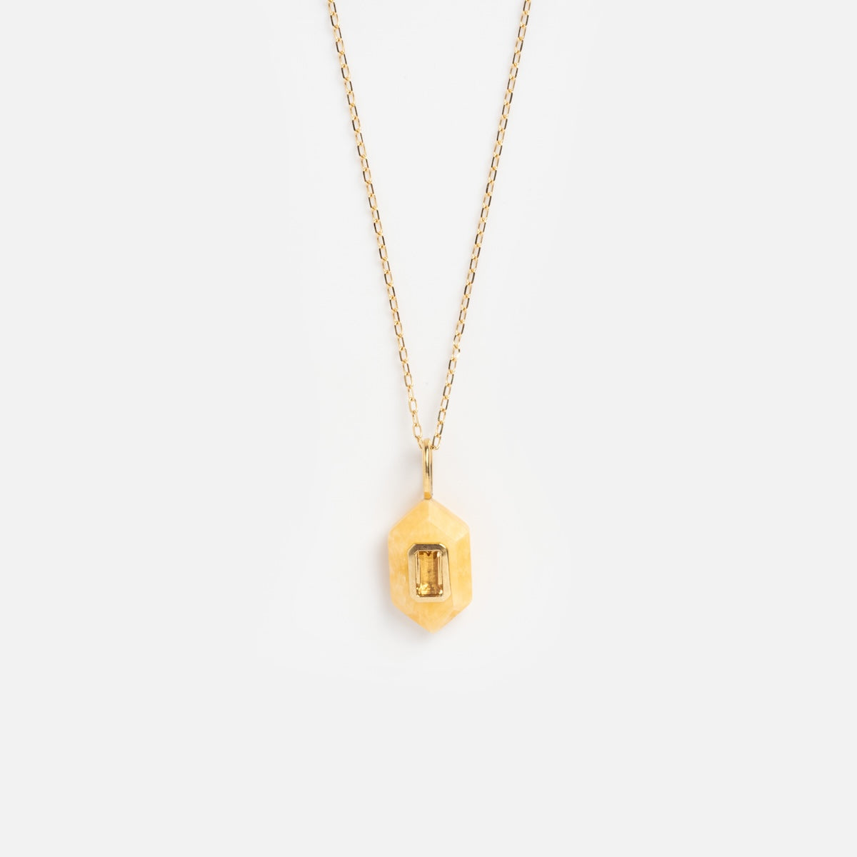 The Solid Gold Large Aura Necklace Yellow Sample features a delicate gold chain and a hexagonal pendant with a rectangular yellow gemstone, shown against a plain white background.