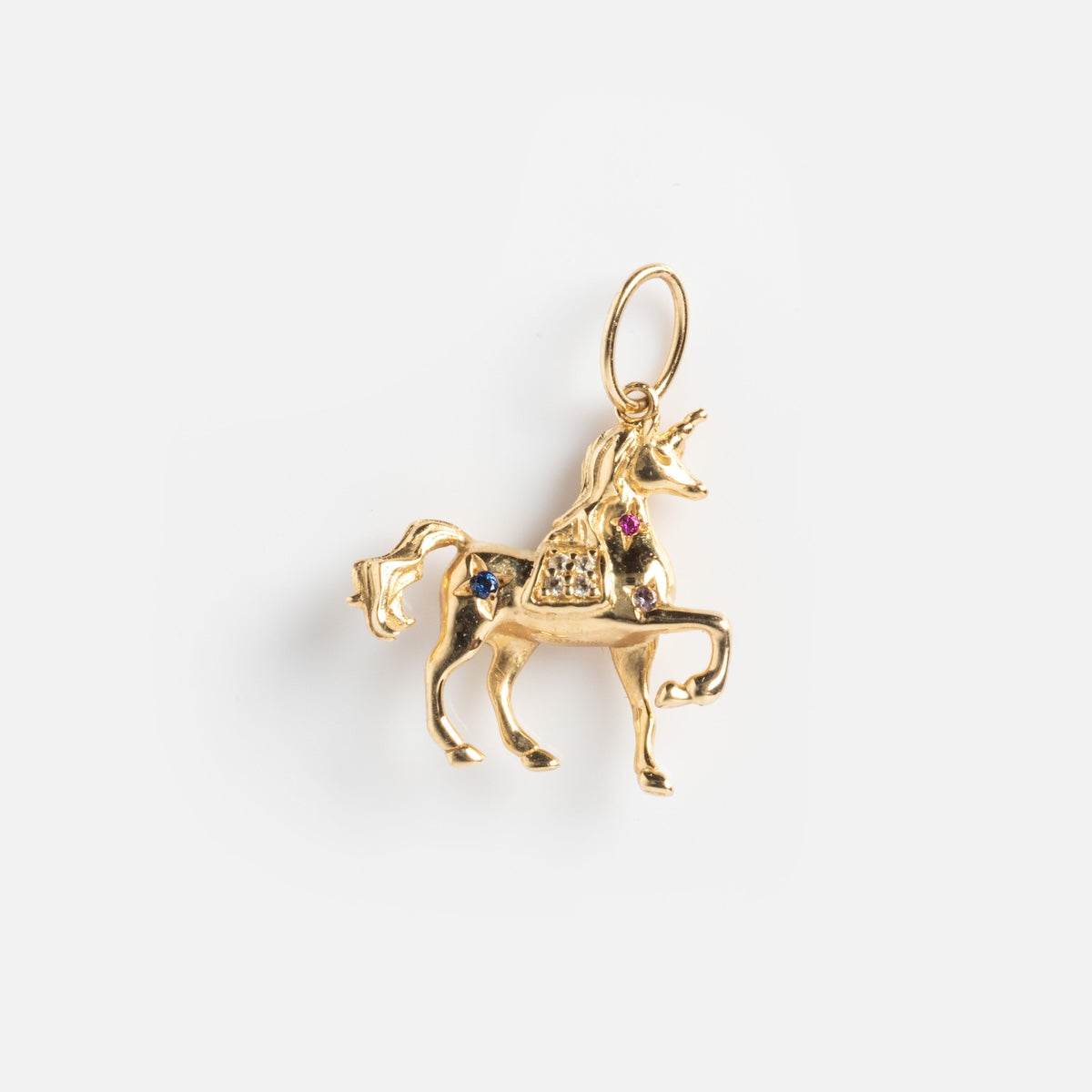 The Solid Gold Lucky Charm is a unicorn charm with a raised front leg, adorned with small colorful gemstones and a loop for attaching to jewelry, shown on a plain white background.