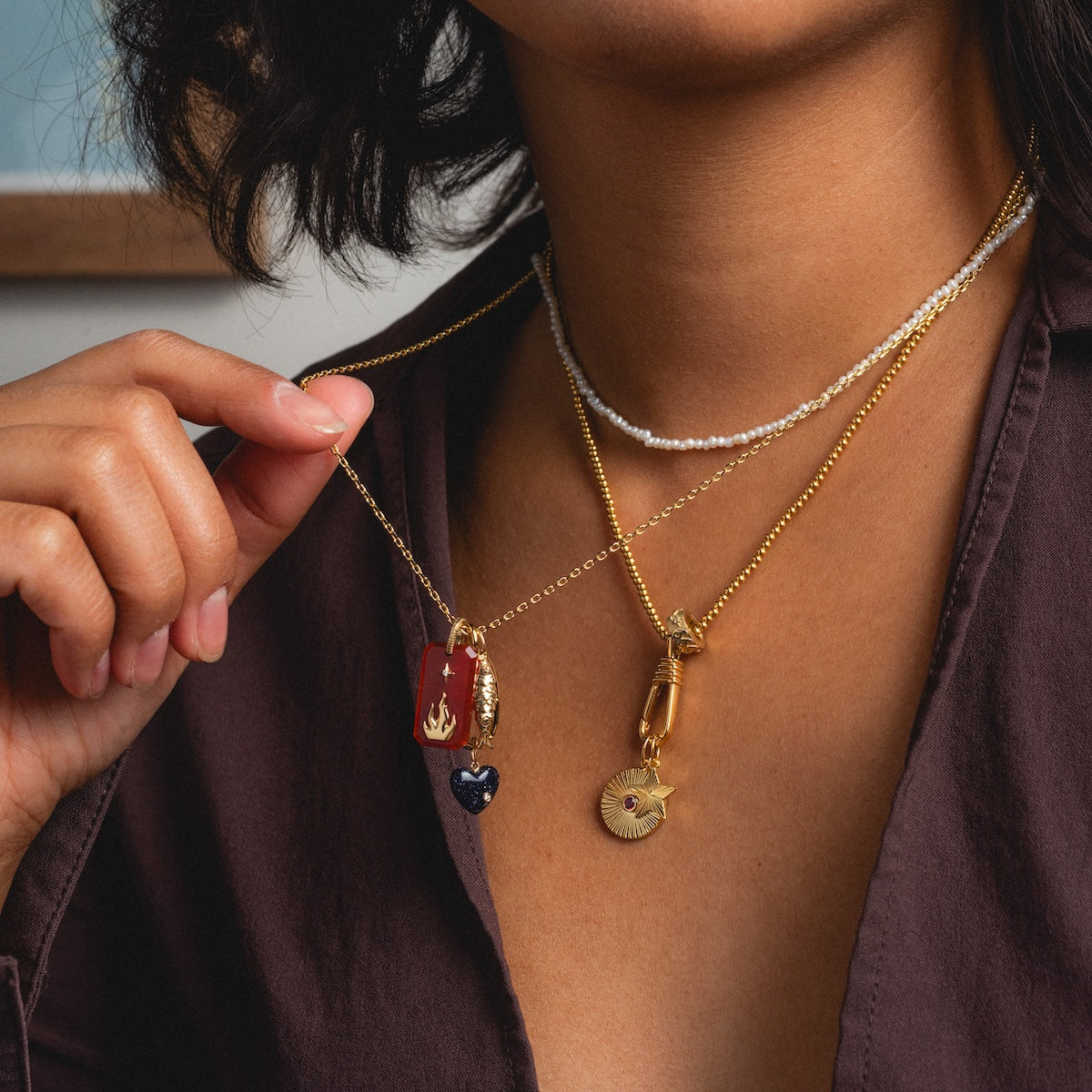 beaded vermeil, pearl, and oval link chain being worn in necklace stack with charms