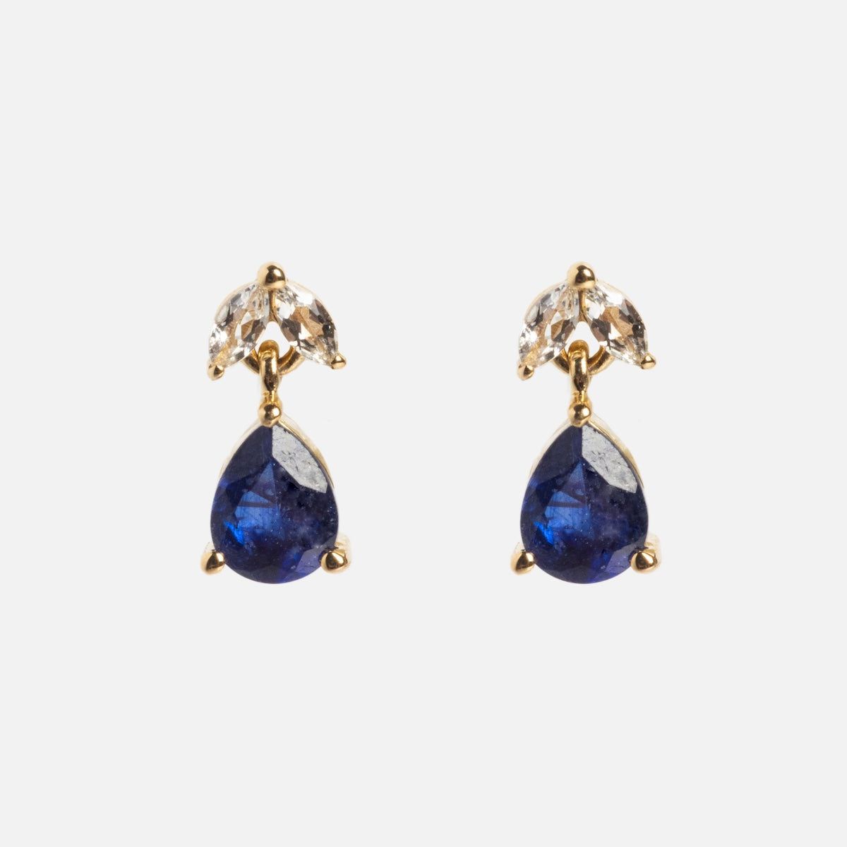 The Solid Gold 2025 September Capsule Classic Blue Sapphire Stud Earrings feature teardrop blue sapphires below two marquise-cut white topaz stones, all set in 9k yellow gold against a plain white background.