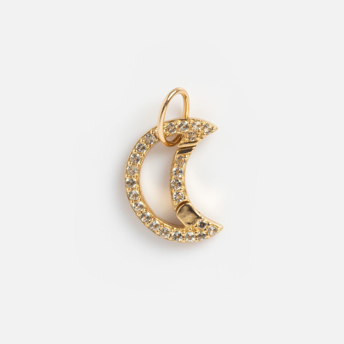A Solid Gold Charm Clip holds a crescent moon pendant encrusted with small, sparkling clear stones, shown on a plain white background.