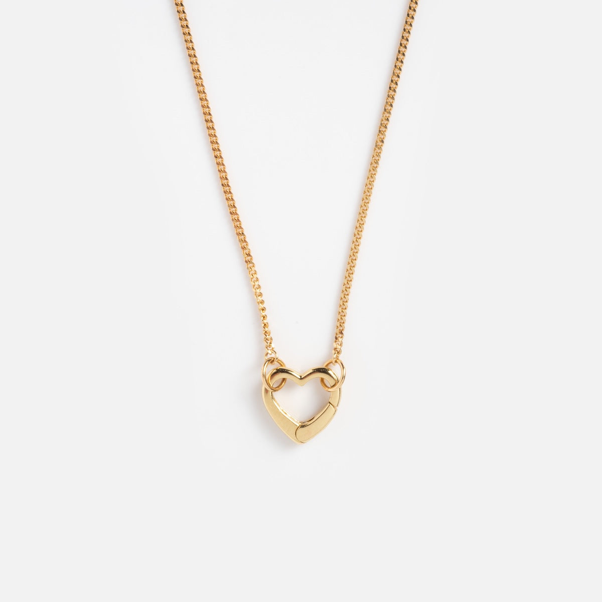 The Solid Gold Perfect Start Charm Holder Necklace features a modern, geometric heart-shaped pendant and is displayed on a plain white background.