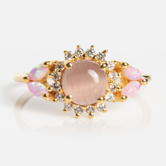 The Pink Opal and Cats Eye Moonstone Sunflower Ring showcases a large oval pink gemstone center, clear stone accents, and smaller oval pink opals on each side.