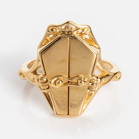 The Limited Edition Til Death Do Us Part Poison Ring is a gold ring with a hinged coffin-shaped lid and intricate scrollwork on the band, shown against a plain white background.