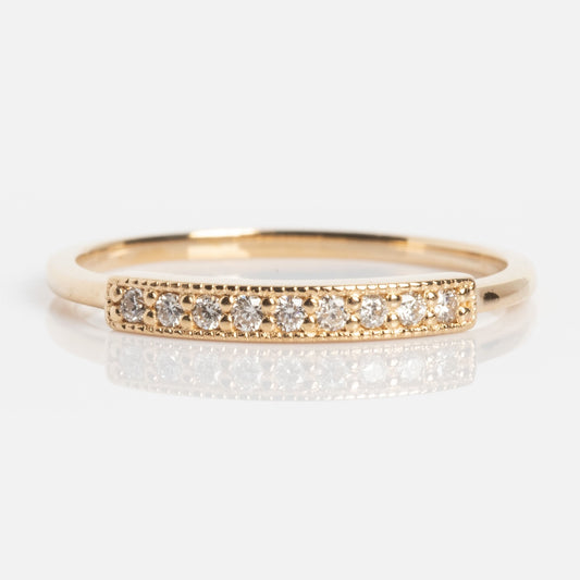 The Clyde Ring is a thin gold band featuring a rectangular bar set with a row of small, round white diamonds, shown against a plain white background.