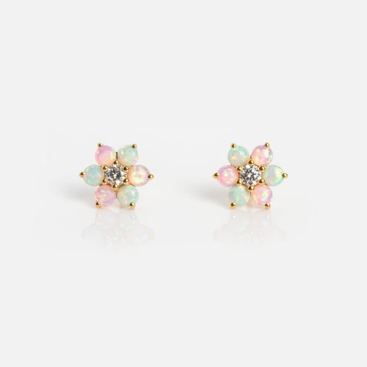 The Tropical Opal Fleur Studs are flower-shaped earrings with round pink and green opal petals, gold settings, and a central cluster of small clear stones, shown against a white background.