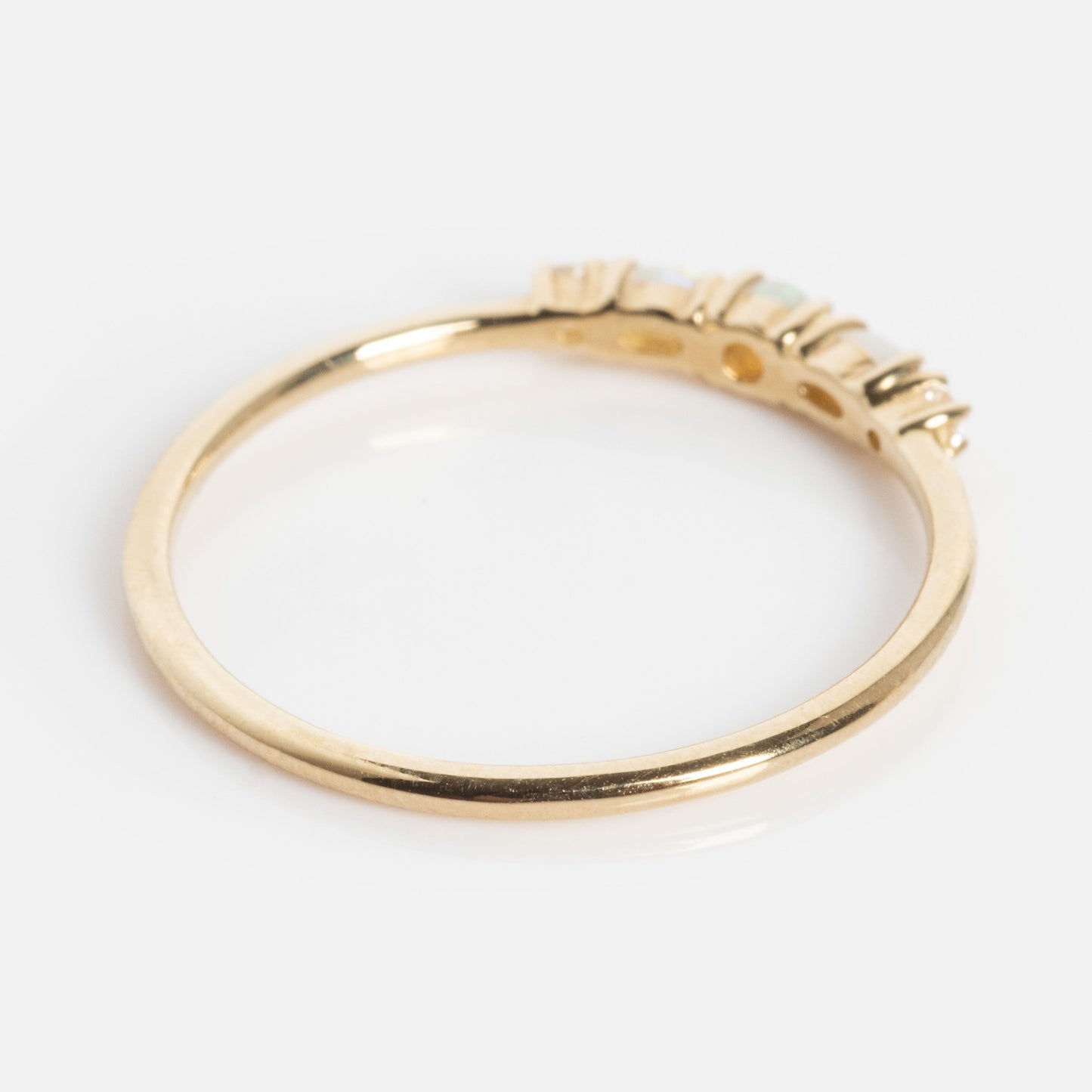 The Solid Gold 2025 October Capsule Classic Opal Trio Statement Ring features a slim gold band with three rectangular opal gemstones set on top, shown against a white background.