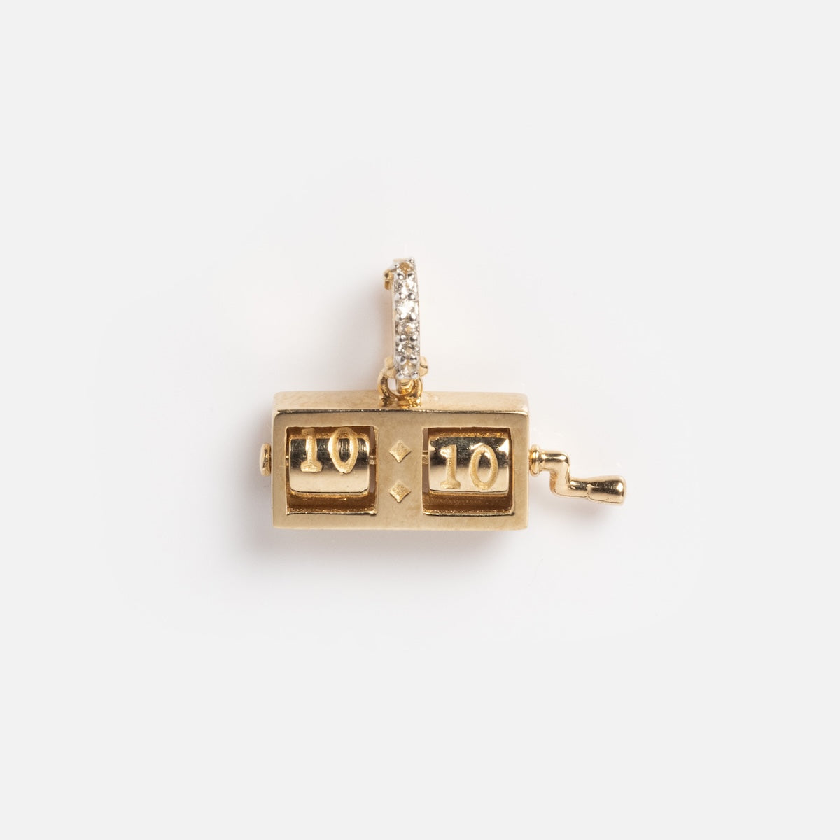 The Solid Gold Lucky Charm features a vintage flip clock design in yellow gold with 10:10 displayed, a side winding handle, and a bail embellished with sparkling white topaz gemstones for an elegant touch.