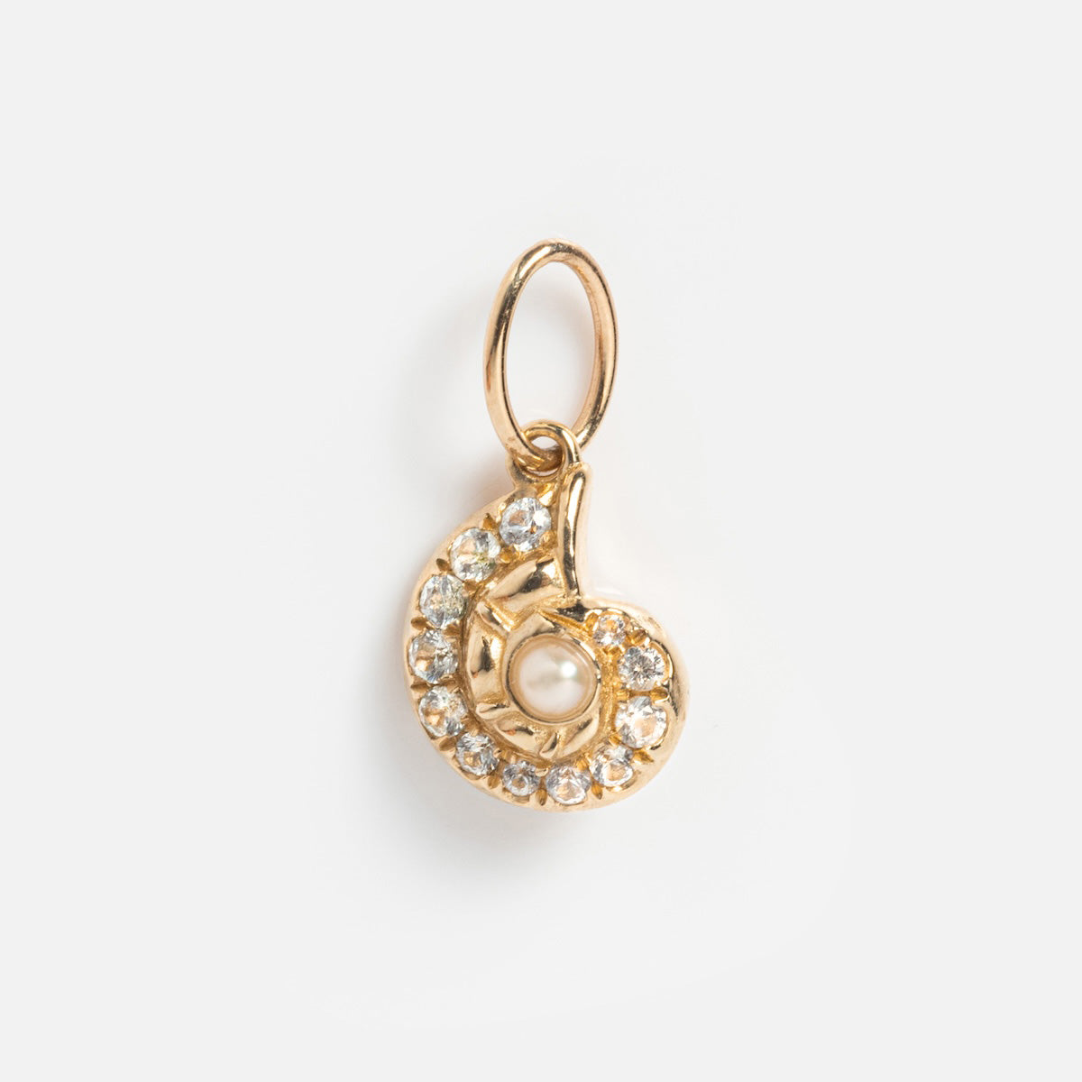 The Solid Gold Nature Charm features a spiral shell design with clear stones on the edge and a central pearl, finished with a small gold loop for easy attachment to your chain—an elegant choice for fans of spiritual jewelry.