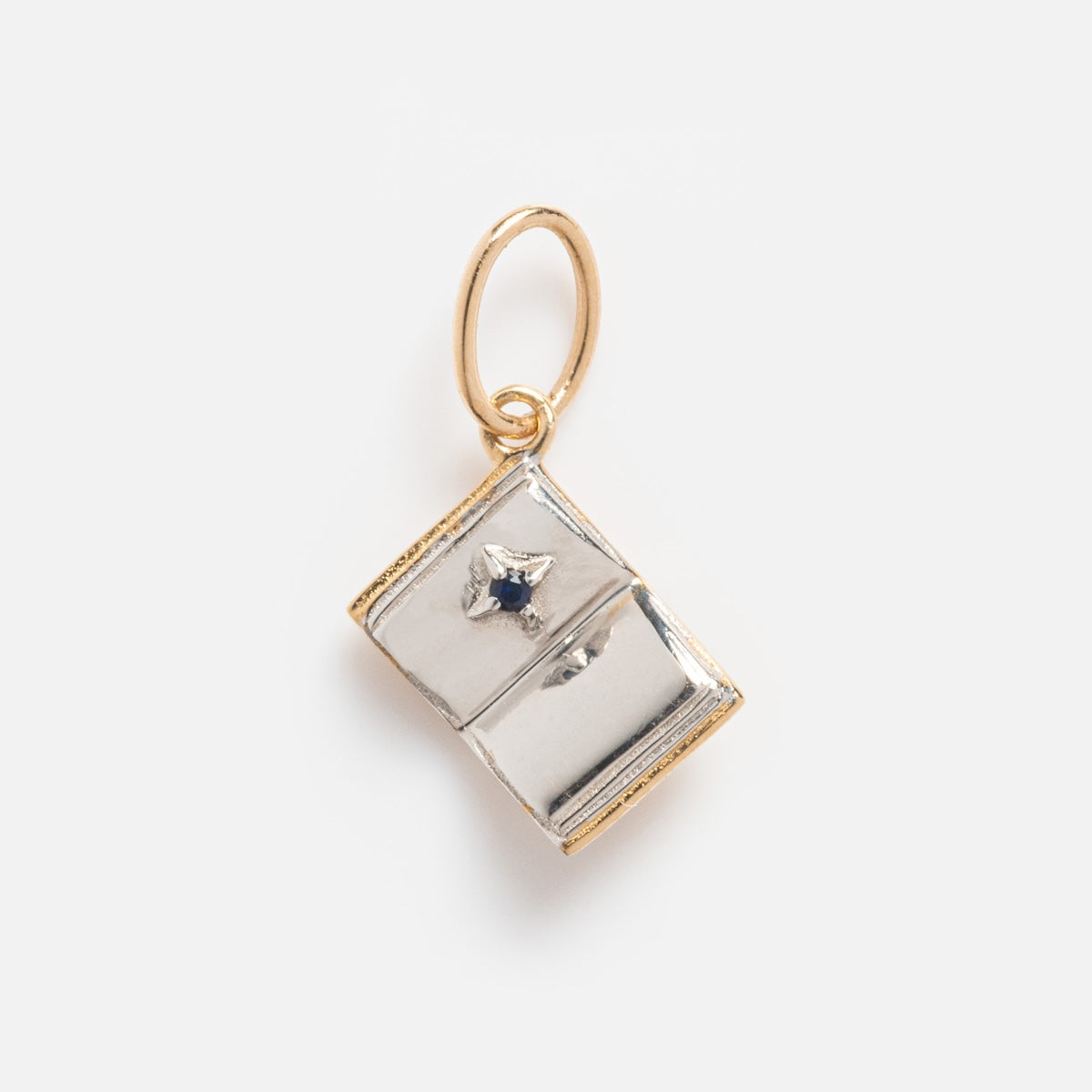 The Solid Gold Statement Charm is a small open book-shaped pendant crafted in 9k yellow gold with gold edges, a gold loop, and a tiny center gem—an elegant statement charm shown on a white background.