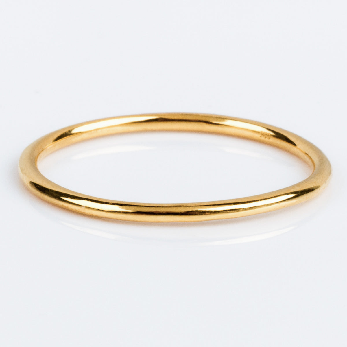 Twiggys Simple Band is a sleek, thin 18K yellow gold ring with a smooth, polished finish, shown against a white background.
