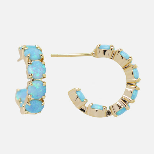 The Oh She Fancy Blue Opal Huggie Hoop Earrings in 18k yellow gold feature five simulated blue opals on each hoop, displayed against a plain white background.