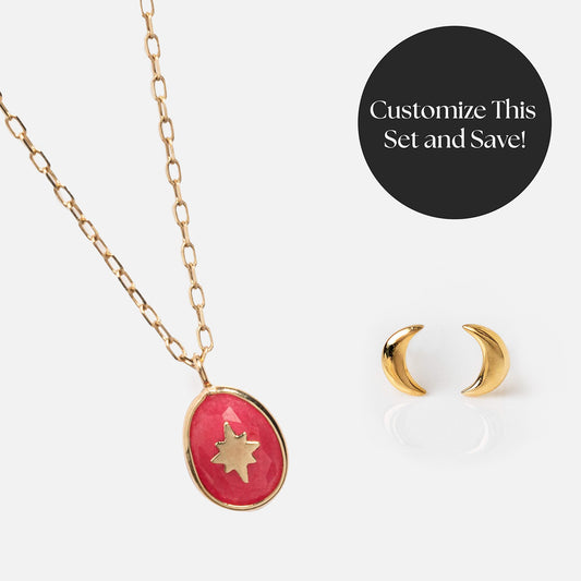 The Solid Gold Moonlight Manifestation Gift Set features a gold chain necklace with a pink oval pendant and gold star, shown with small gold crescent moon earrings. This set invites you to “Customize This Set and Save!”.