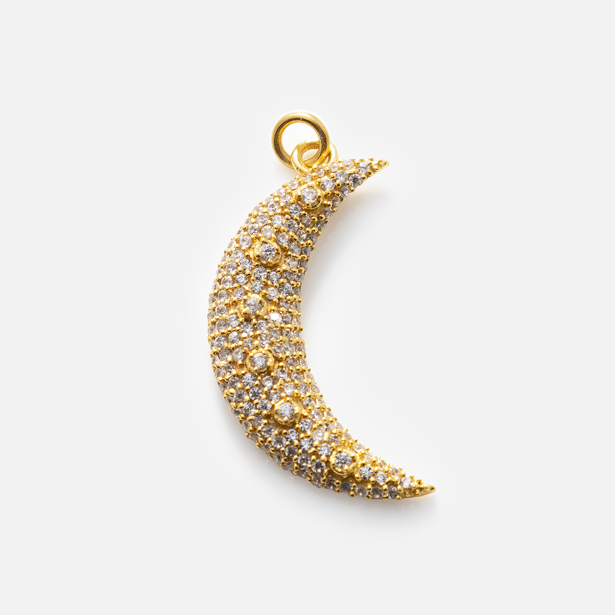 A sparkling gold crescent moon pendant with cubic zirconia crystals from Charms by Anokhi Green, shown on a white background. Wear as a cubic zirconia necklace or pair with other gold plated charms from the collection.