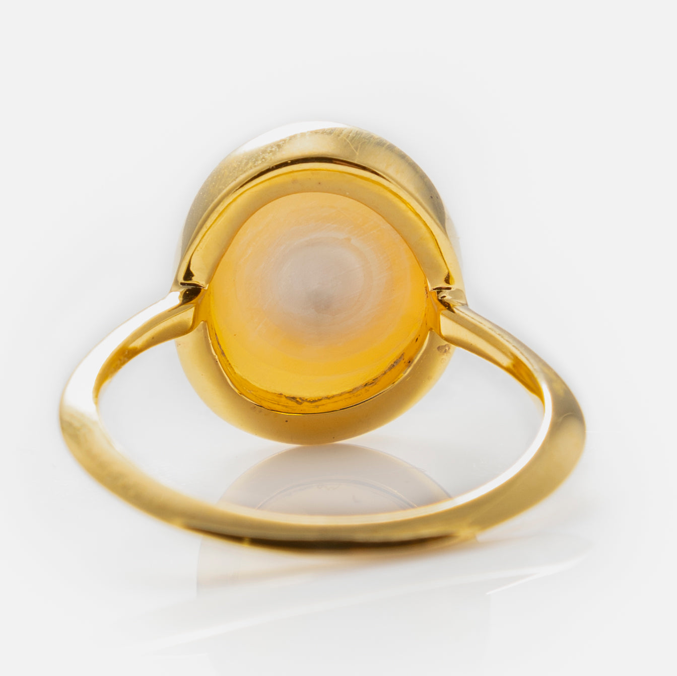 The Simple Semi Precious Pearl Ring features a gold vermeil band and a round, yellowish-white semi-precious pearl in a bezel setting, shown from the back to highlight the open gallery and the stone’s base.