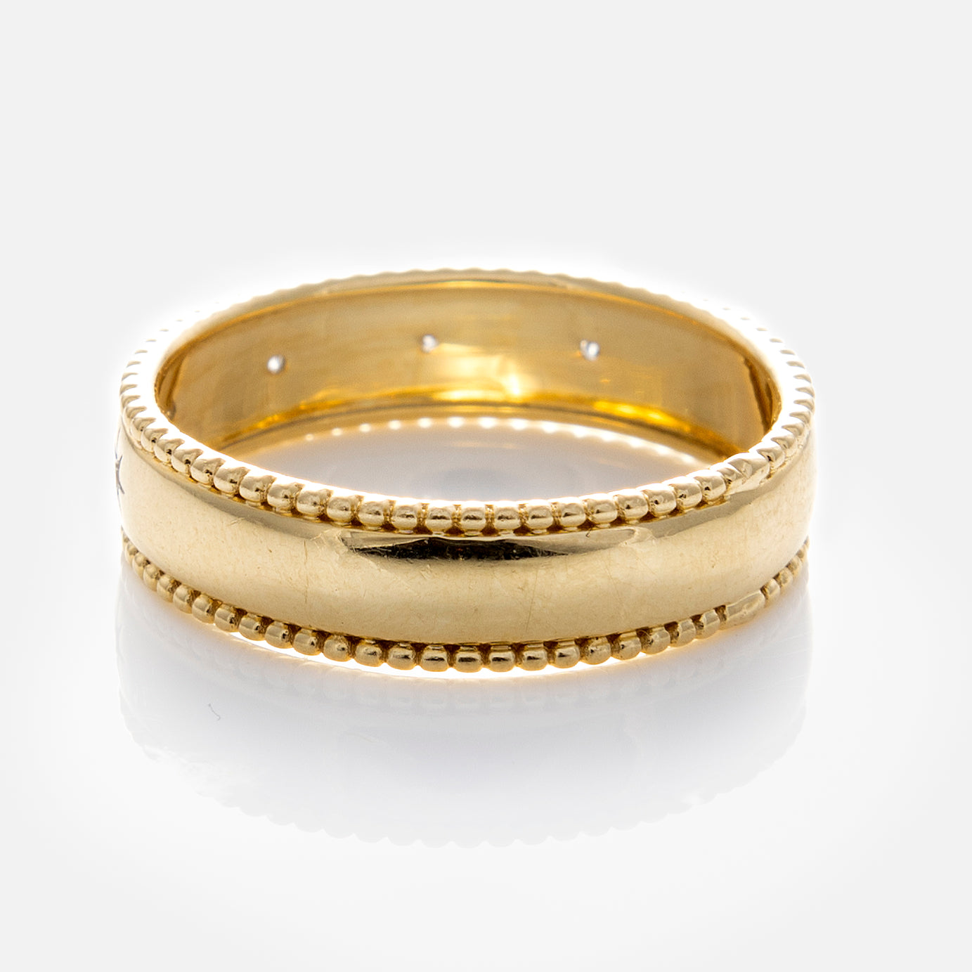 The Solid Gold Bold Star Set Diamond Band, shown against a white background with a reflective surface, is perfect as a stacking ring for any jewelry collection.