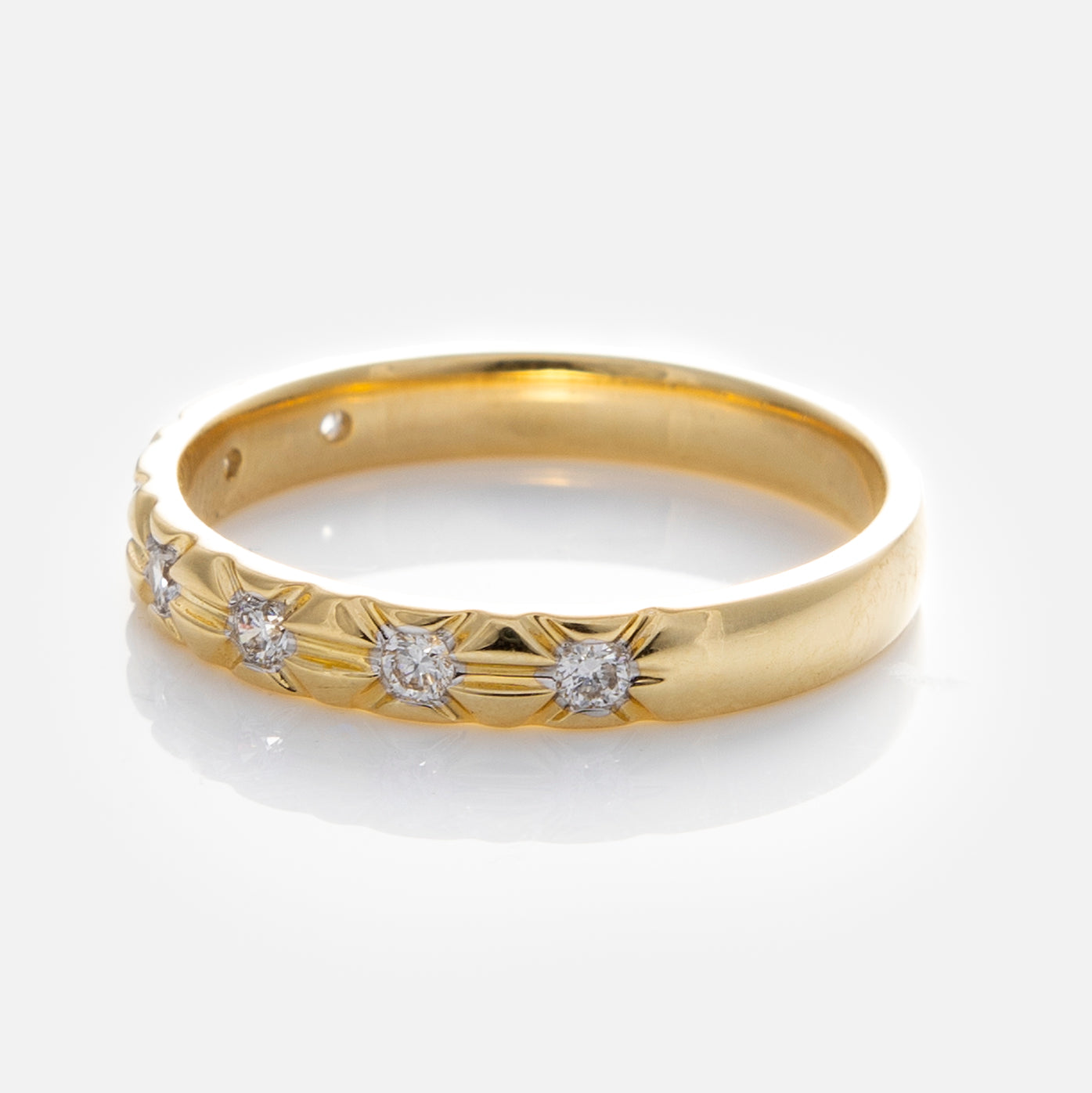 The Solid Gold Vintage Inspired Diamond Band features five small round lab grown diamonds set in a row with subtle engraved details around each stone, beautifully displayed on a white background.