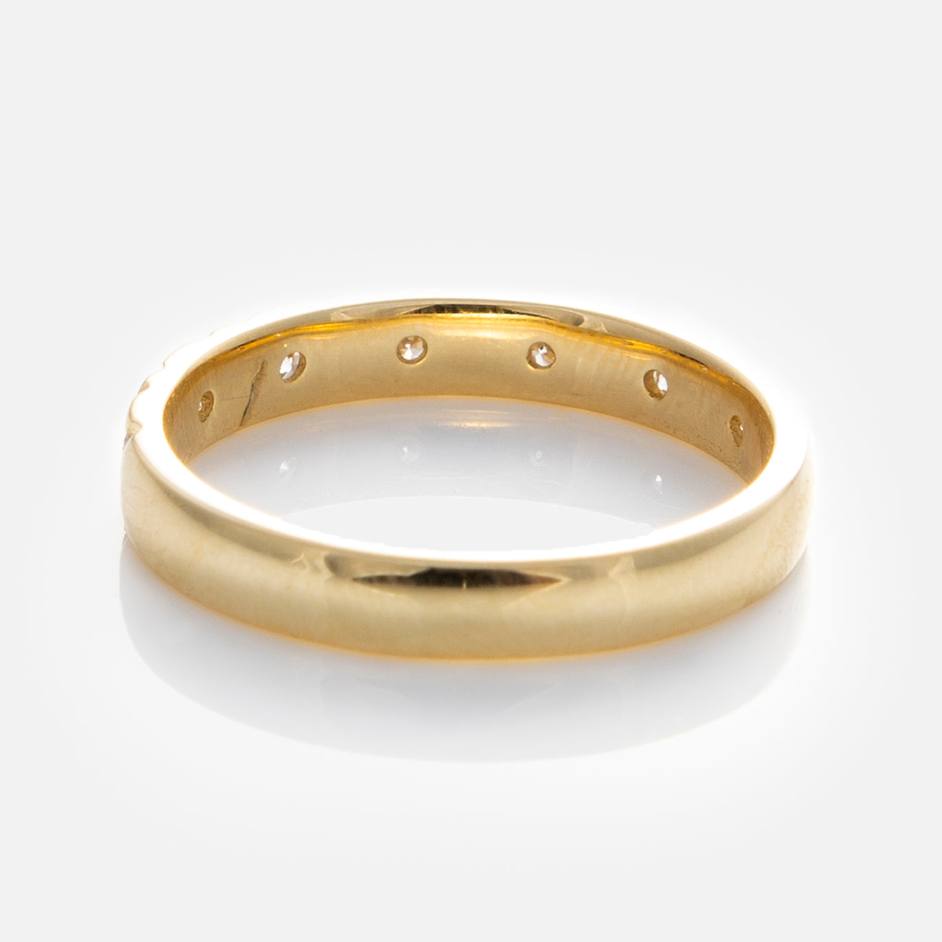 The Solid Gold Vintage Inspired Diamond Band features a smooth, polished finish with subtle inner detailing, elegantly displayed on a white background.