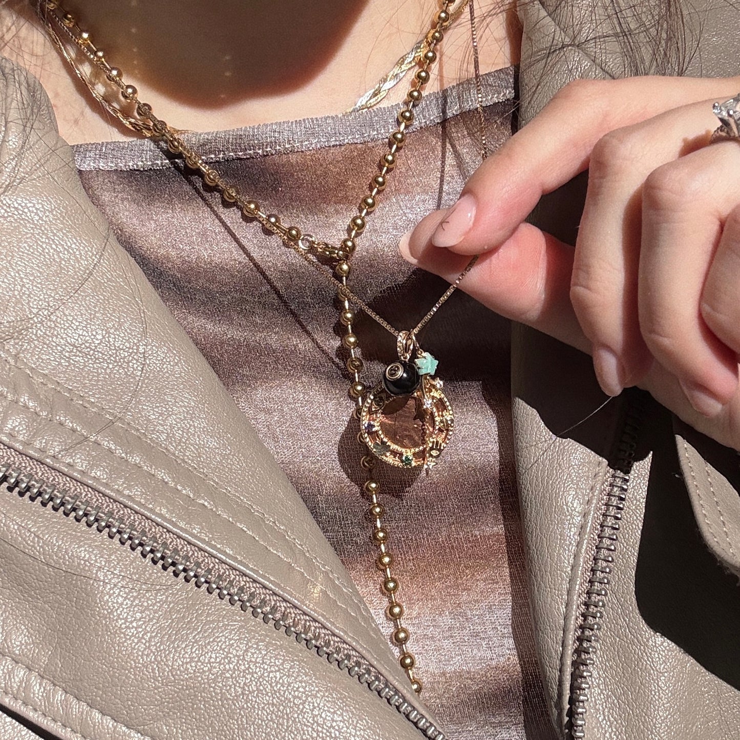 Close-up of a person wearing multiple necklaces with intricate designs.