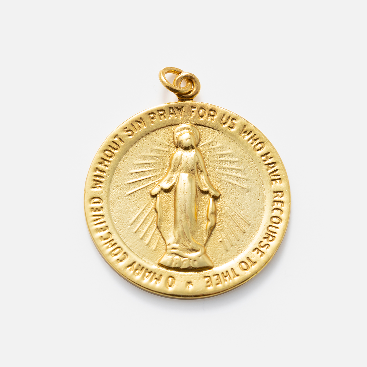 A gold oval religious medal, such as Charms by Anokhi Green, features an embossed Virgin Mary and the inscription: O Mary conceived without sin pray for us who have recourse to thee.