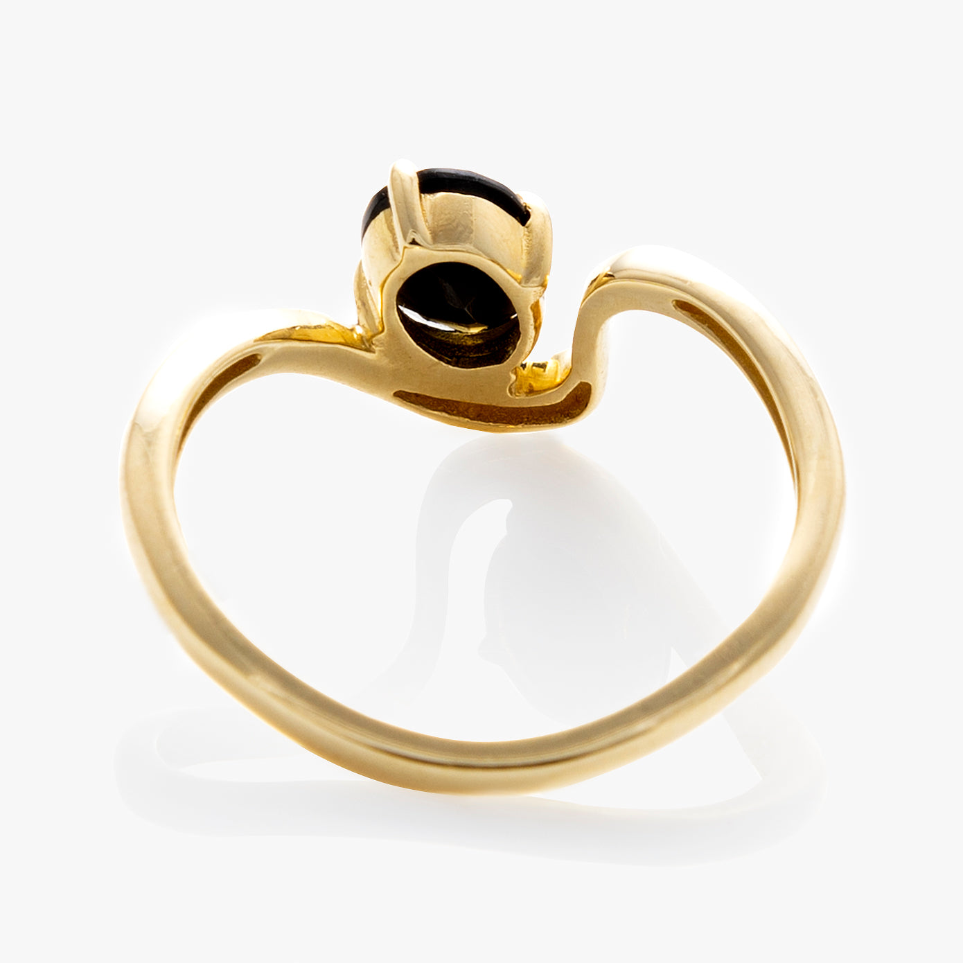 The Solid Gold Floating Gem Ring features a wavy, irregular gold band and a dark oval stone in an abstract setting, creating the look of a gemstone floating atop the ring. Displayed against a white background.
