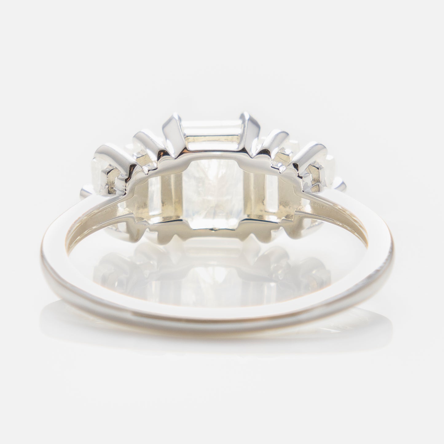 A close-up of the Moonstone Deco Ring in Silver showcases its vintage-inspired design with a rectangular moonstone center and smaller stones on the band, viewed from the back to reveal intricate gemstone settings.
