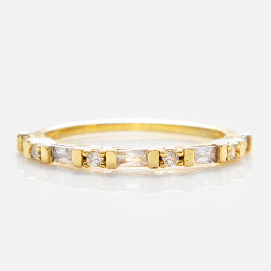 The Gatsby Stacking Ring is a 14k yellow gold plated band with alternating rectangular and round clear cubic zirconia stones in a continuous pattern, shown on a white background.