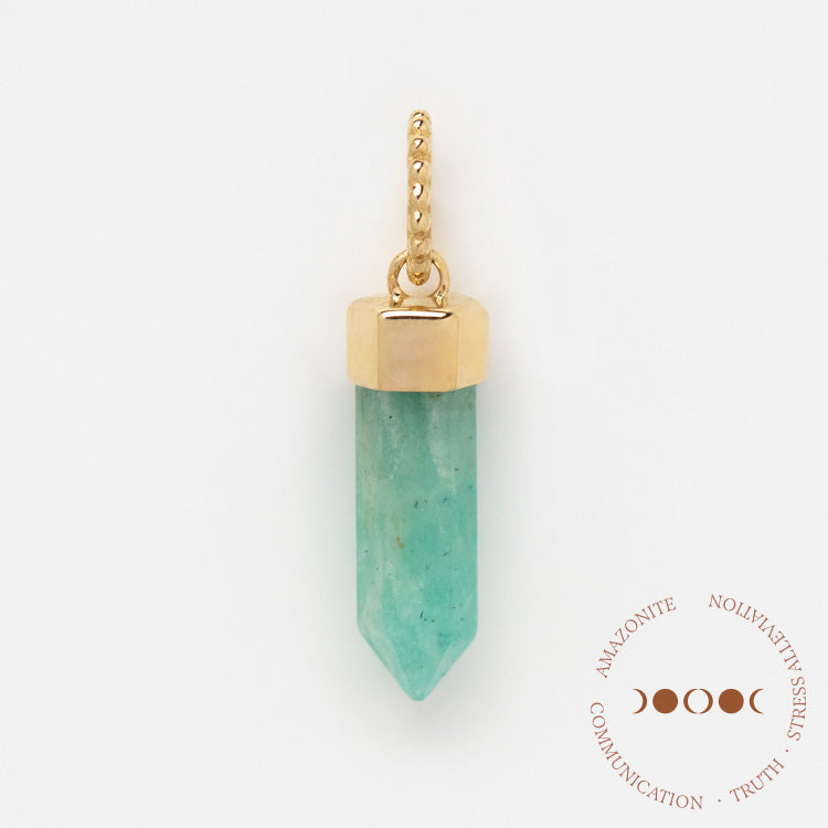 A Solid Gold Crystal Charm for Manifestation with a gold-capped, pointed amazonite and textured gold loop rests on a white background. A circular graphic highlights amazonite’s qualities: communication, truth, and manifestation.
