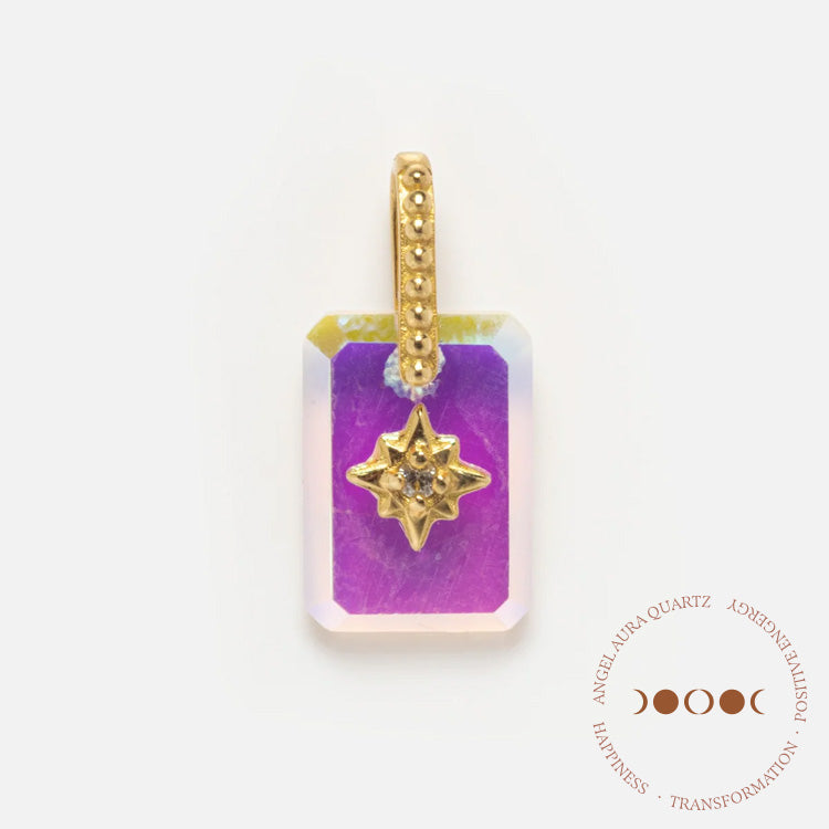 The Solid Gold Crystal Amulet Charm for Manifestation features a rectangular pendant with a gold beaded loop, an iridescent purple natural crystal gemstone, and a gold starburst design at its center. A circular emblem appears in the lower right corner.