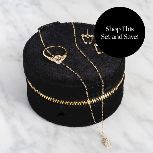 The Solid Gold 2025 April Capsule White Topaz Statement Set with Free Gift features a ring, necklace, and earrings displayed on black velvet. Perfect for April birthdays, this eye-catching set stands out on white marble. Shop now and save!.