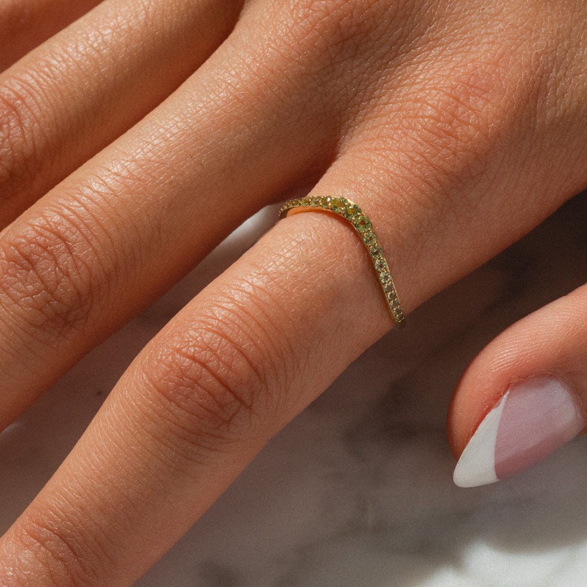 Close up of peridot stacking ring worn on finger
