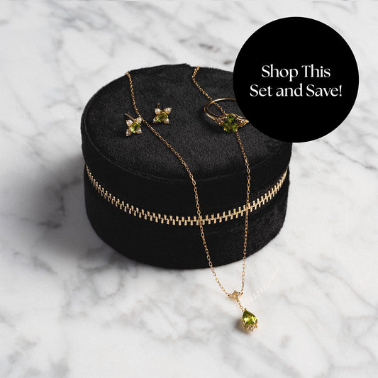 Peridot statement ring, necklace, and earrings displayed on top of jewelry box