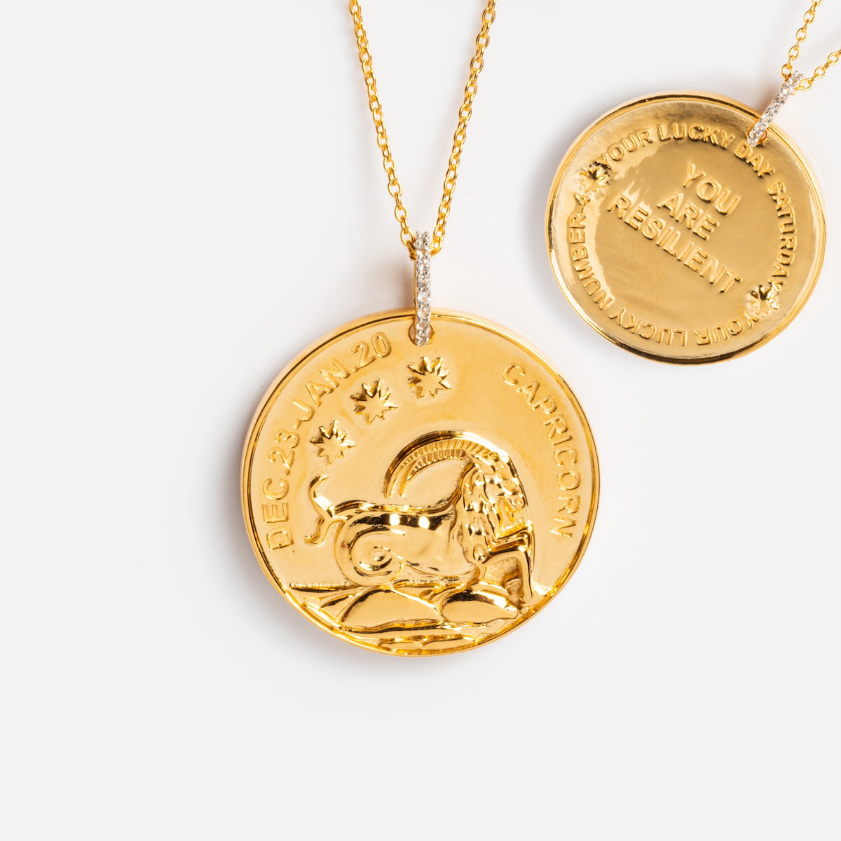 Two Vintage Inspired Zodiac Coin Necklaces: the front features a Capricorn symbol with DEC 23–JAN 20 and CAPRICORN engraved; the back reads Your Lucky Attribute: You Are Resilient.