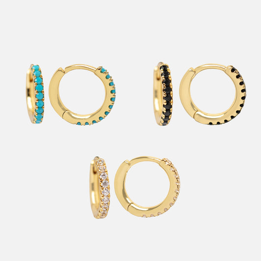 Five pairs of Classic Gem Huggie Hoops—14k gold plated, set with small gemstones in turquoise, black, clear, and champagne—ideal for vibrant earring stacks, all shown on a plain white background.