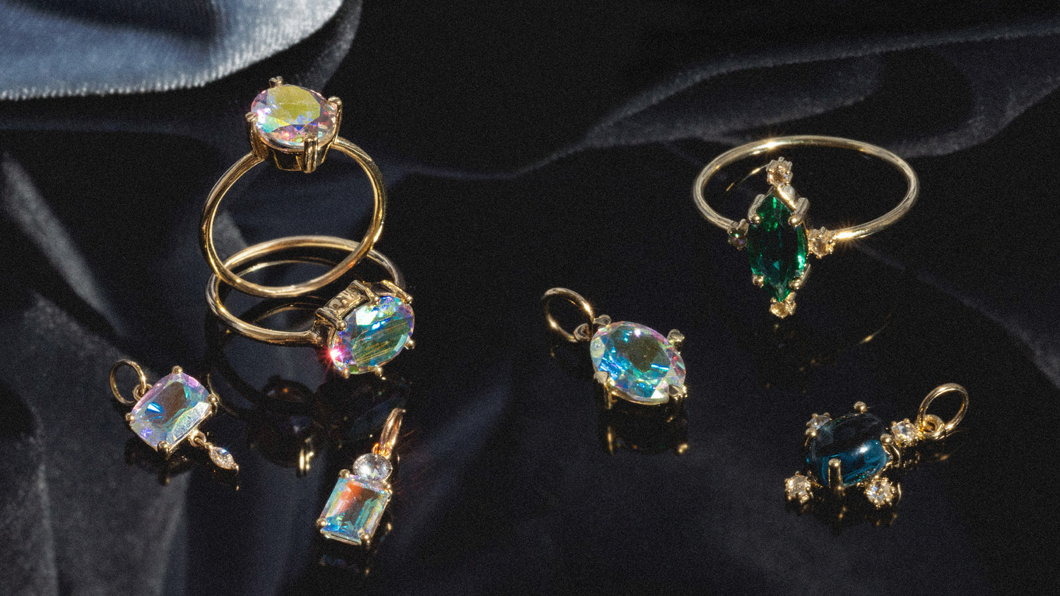 Gold gemstone jewelry laying on dark velvet fabric