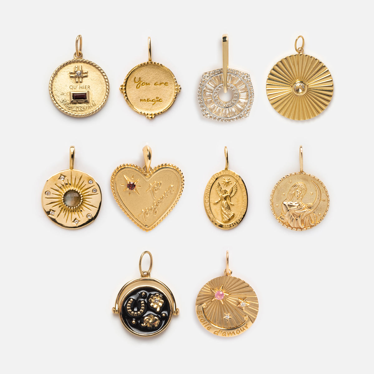 Ten Solid Gold Coin Charms arranged in three rows, featuring engraved designs, celestial and zodiac motifs, gemstones, textured patterns, and inspirational words. Each Local Eclectic exclusive includes a loop for attaching to a chain.
