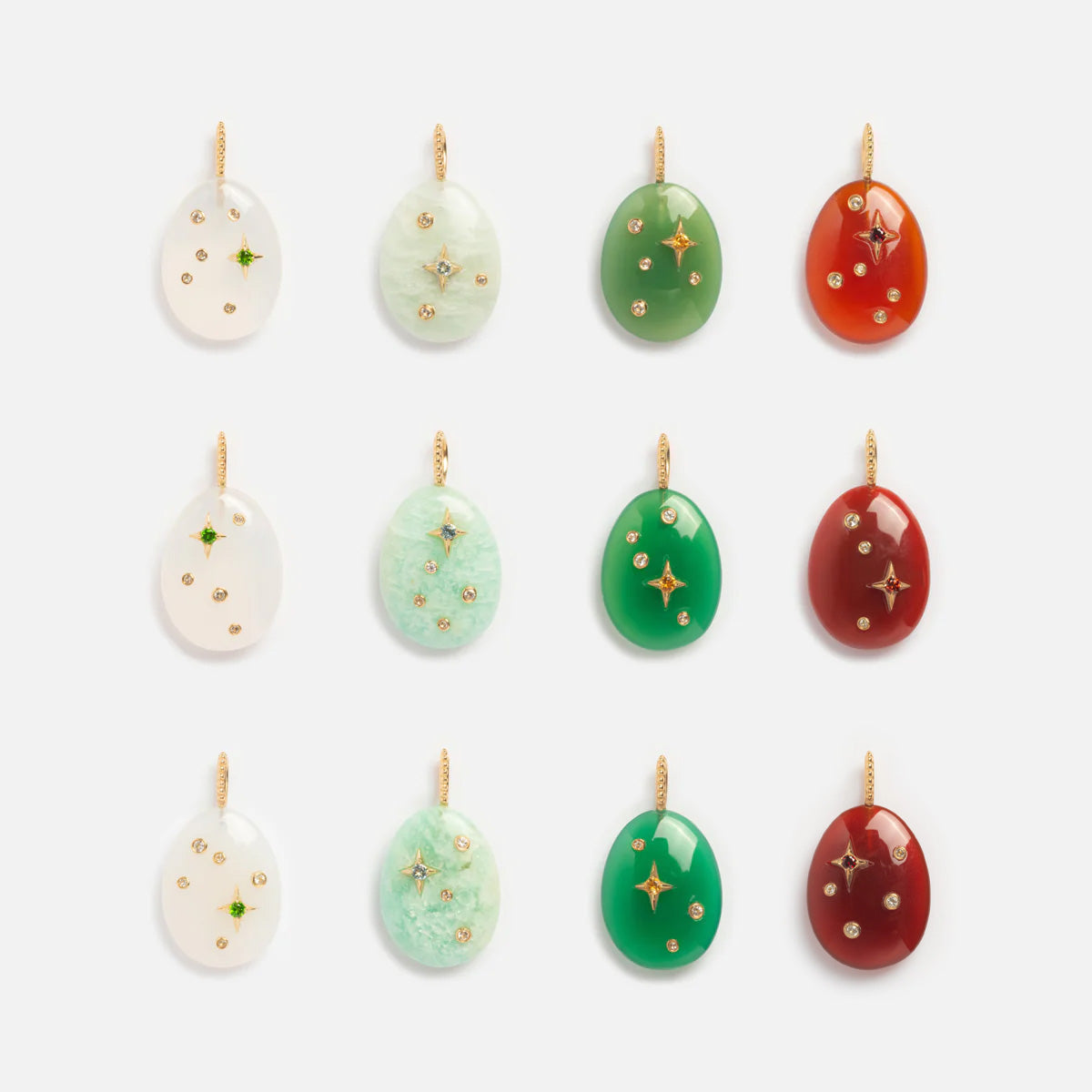 Twelve Solid Gold Zodiac Constellation Crystal Charms in various colors, each oval-shaped with gold stars and dots, are arranged in three rows of four on a white background.