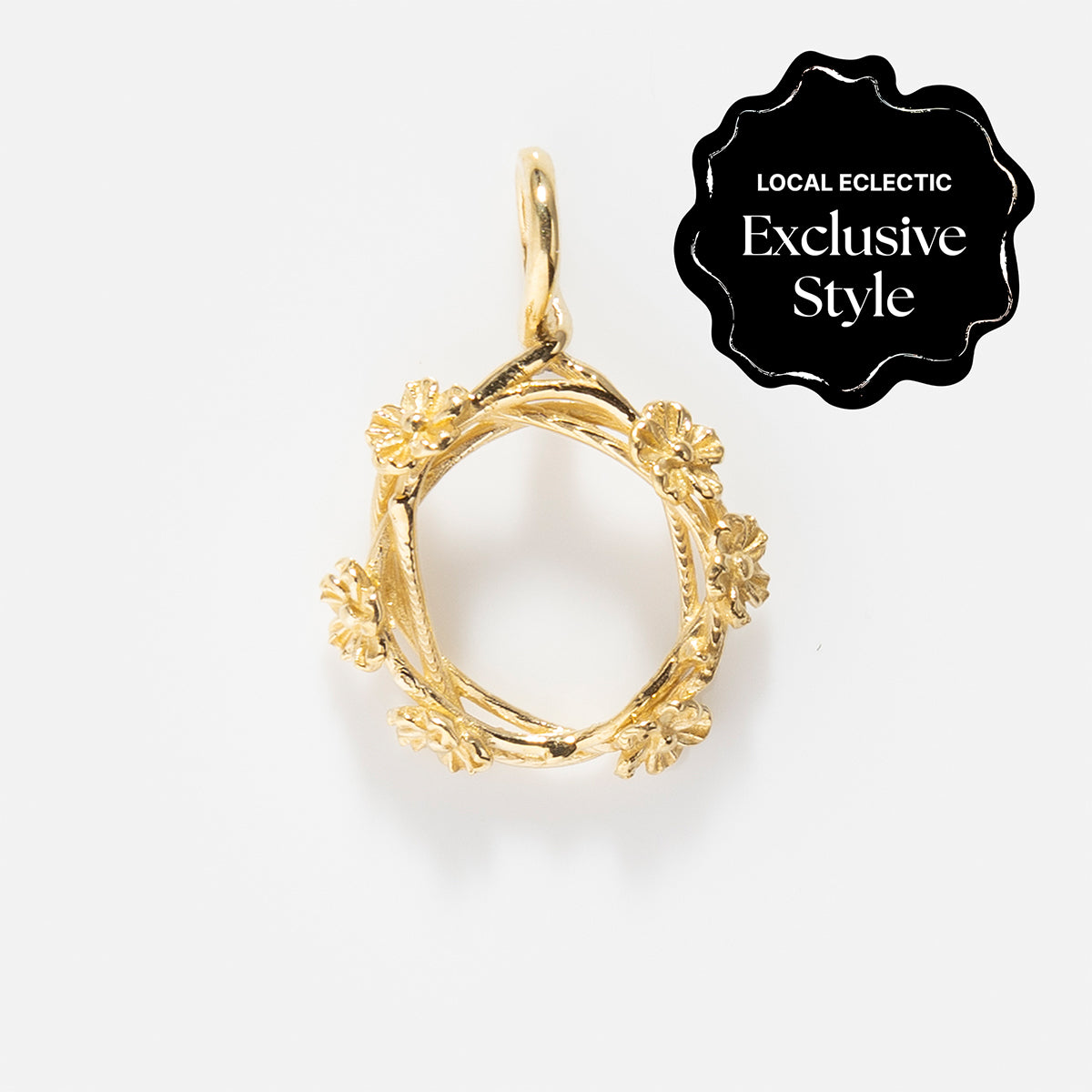 Charms by I Like It Here Club: Gold floral wreath pendant with intricate flower details and 12k yellow gold plating, displayed on white. A black seal in the corner marks it as a “Local Eclectic Exclusive Style,” adding personalized flair.