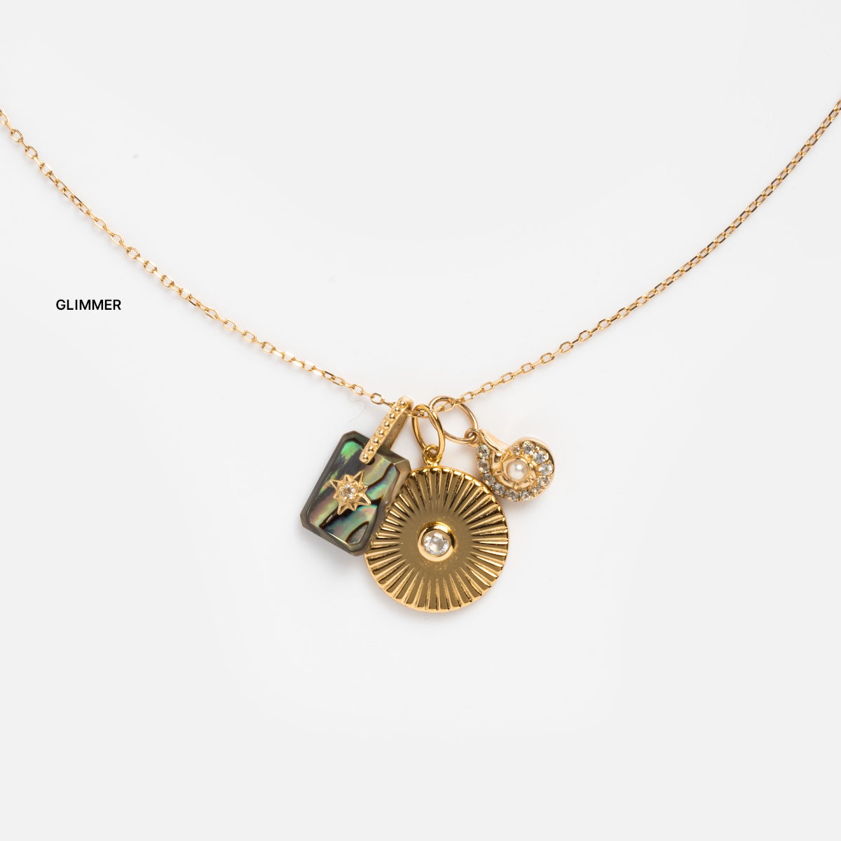 The Solid Gold Chain for Charms is shown on a plain white background, featuring three pendants: a rectangular abalone star, a round sunburst, and a small crystal.