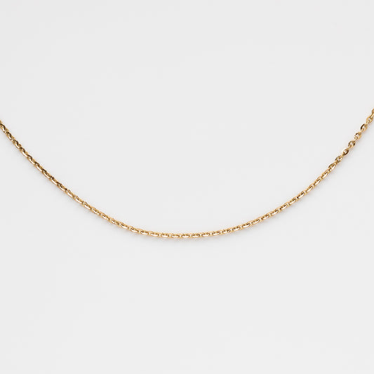 The Solid Gold Simple Glimmer Gold Chain is a delicate 9k gold necklace featuring small, evenly spaced links, shown against a plain white background.