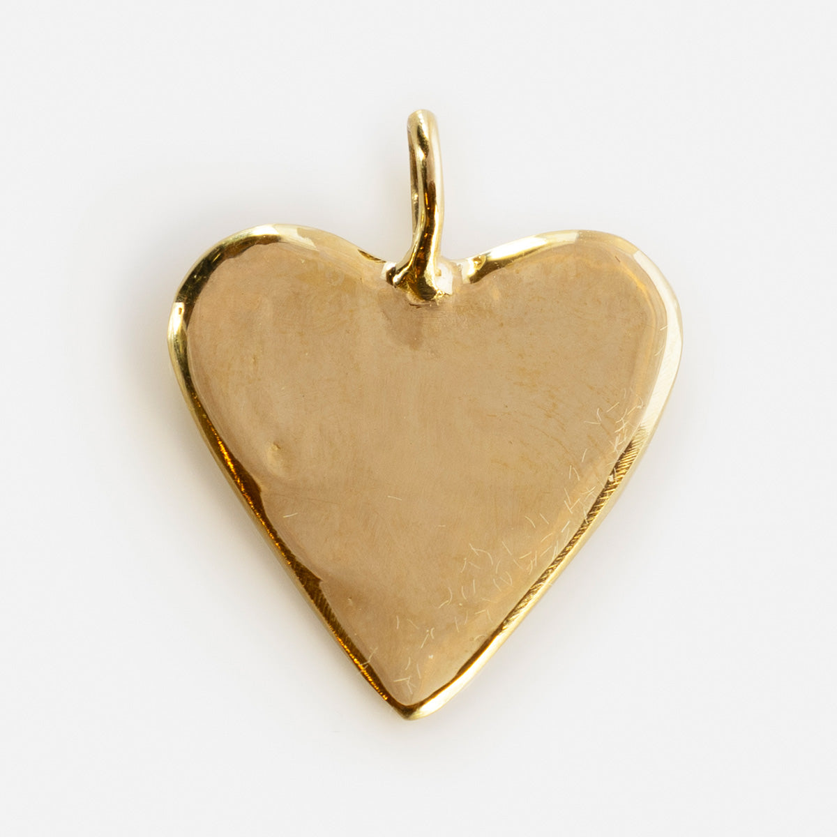 A shiny, gold, heart-shaped Luiny x Local Eclectic Charms pendant with a smooth surface and a small top loop for attaching to a necklace, displayed on a plain white background.